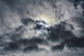 Sky, sunlight. Background. Blue sky with clouds, from behind the clouds the sun peeps.