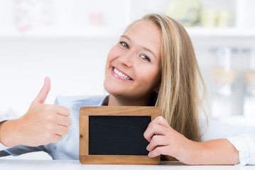 junge frau mit tafel zeigt daumen hoch