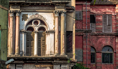 Building exterior of a weathered ancient worn out colonial style architectural structure for background content.