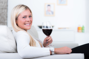 glückliche junge frau trinkt rotwein