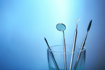 Dental equipment in glass on color background