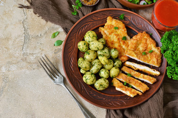 Schnitzel with potatoes and salad for lunch on a concrete background