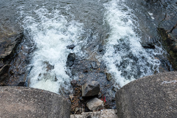 Water flows from the drain pipe into the river