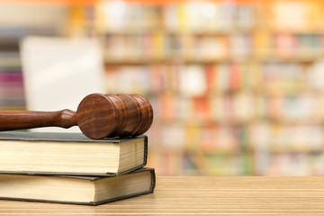 Wooden gavel and books on wooden table