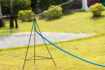 Fototapeta premium Close up of lawn sprinkler with green grass