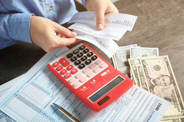 Woman working with calculator and documents. Tax concept