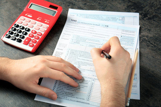Man working with calculator and documents. Tax concept