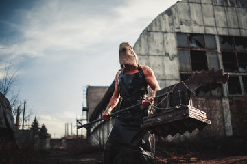 Mutant monster with weapon in form of hammer, saw and an ax. Imagination. © Stanislav