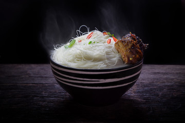 Instant vermicelli with roast pork spareribs in the bowl on wooden background