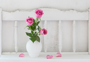 pink rose on white wooden shelf