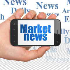News concept: Hand Holding Smartphone with Market News on display