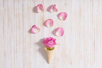 Flowers in a waffle cone on white wooden background