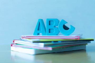 ABCs symbols placed on a stack of educational children's books.