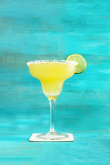 Lemon Margarita cocktail on vibrant turquoise with copyspace