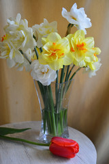 bouquet of daffodils in a glass vase on round table