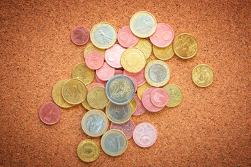 Top view Euro coins collection on cork board as business, money, banking, currency concept - can...