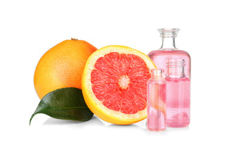 Perfume bottles and grapefruit on white background