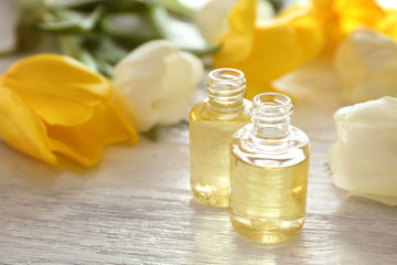 Perfume bottles and tulip flowers on table
