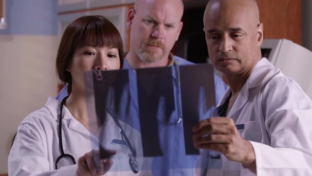 Three doctors look over x-rays together