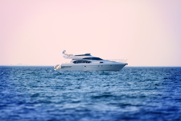 Obraz premium A yacht is sailing on the sea. The day is beautiful and it is summer time.