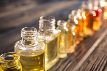 Perfume bottles on wooden table - obrazy, fototapety, plakaty