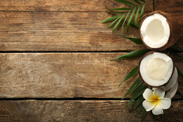 Fototapeta na wymiar Fresh coconut oil in half of nut on wooden background