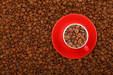 Coffee beans in red cup with saucer top view