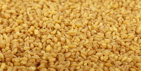 Yellow bulgur big grains close up background