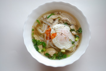 Bowl of vietnamese chicken pho with an poached egg. Pho ga with egg. Rice noodle soup.