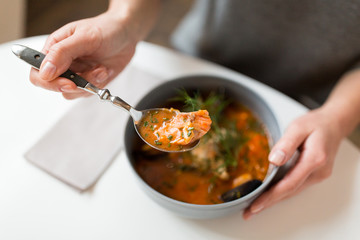 woman eating seafood soup at restaurant