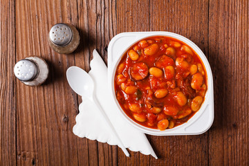 Baked beans in tomato sauce served in plastic cups.