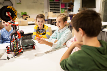 happy children with 3d printer at robotics school