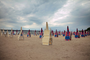 The day is cloudy and it is morning time that is why none of the tourists has come out to the beach yet. The deckchairs and sunshades are closed.