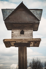 Old birdhouse on a cloudy sky