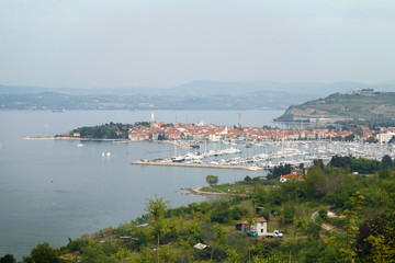 Watching a beautiful sea town in the distance down from a cliff. It is summer time.