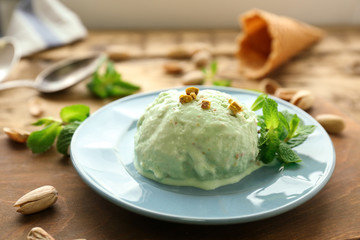 Plate with tasty pistachio ice cream on table