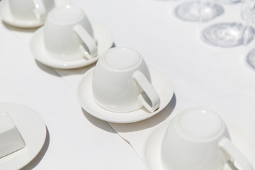 white coffee cups upside down on saucers