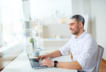 Obraz na płótnie Canvas happy businessman typing on laptop at office