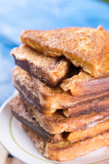 Flat lay pile of triangled french toast above blue wooden background table