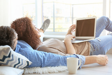 Happy young couple with laptop at home