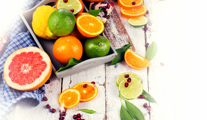 Fresh citrus fruits on a white wooden table.