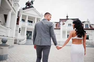 Young fashionable lovely couple at wedding anniversary and marriage proposal day against royal palace.