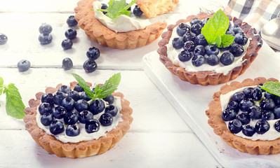 Sweet Blueberry tarts on a white wooden background