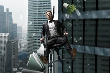 Fotobehang Mann stürzt im Bürostuhl aus Hochhaus © lassedesignen