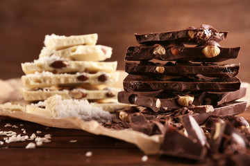 Dark and white chocolate with nuts on brown background