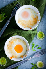 Eggs baked in portioned ramekin with onion, top view, selective focus