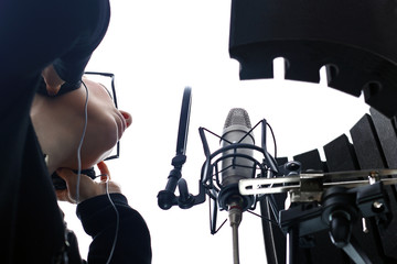 Kobieta nagrywa głos w studio nagrań. - obrazy, fototapety, plakaty