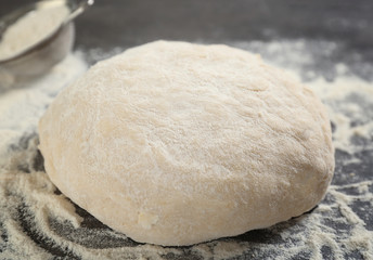 Fototapeta na wymiar Raw dough on kitchen table, closeup