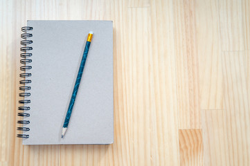 Notebooks and pencils on wooden board