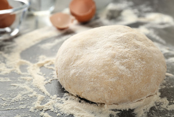 Fototapeta na wymiar Raw dough on kitchen table, closeup